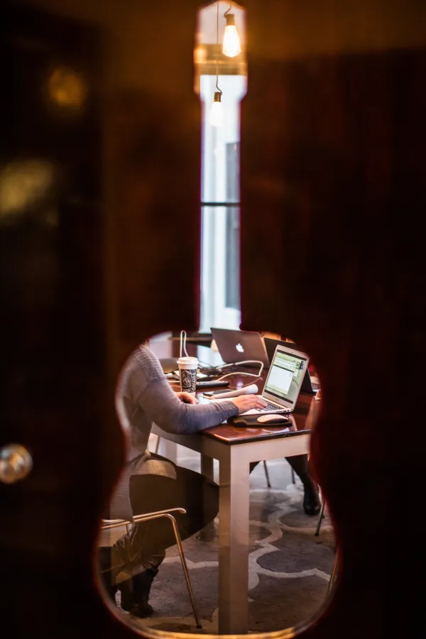 image looking into an office through a guitar-shaped hole in the door